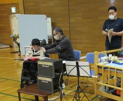 生徒と担任がリコーダー演奏する準備をしています